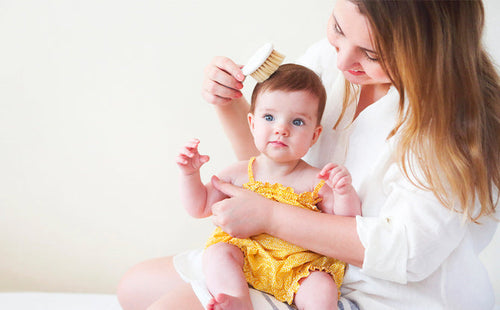 Mom using baby hair products on child - Mustela USA - 1