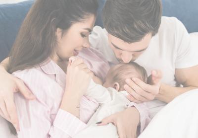 Mom breastfeeding baby while dad kisses baby's head - Mustela USA - 1