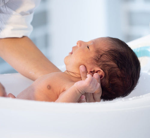 Parent giving baby's first bath - Mustela USA - 1