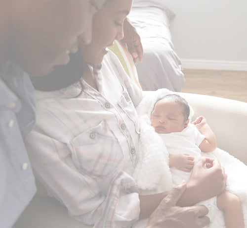 Parents holding newborn while thinking of birth announcement ideas - Mustela USA - 1