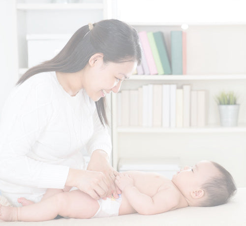 Parents changing baby diaper - Mustela USA - 1