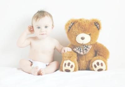 Baby sitting next to teddy bear  - Mustela USA - 1