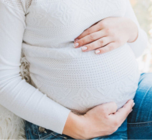 Woman holding belly while experiencing quickening  - Mustela USA - 1