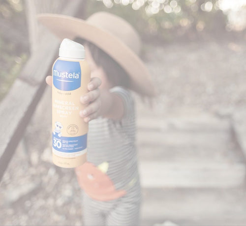Kid holding Mustela spray sunscreen - Mustela USA - 1