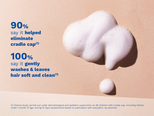 White foam on a beige surface with blue text on the left side. - Mustela USA - 2