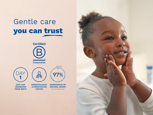 Young child smiling while touching their cheeks, with blue icons and text on the left side. - Mustela USA - 5