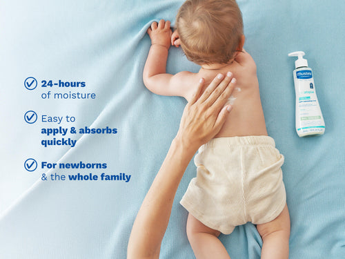 Baby lying on stomach while caregiver applies moisturizing cream. - Mustela USA - 2