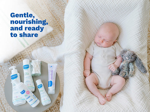 Mustela USA | Sleeping newborn with a stuffed bunny next to a flatlay of Mustela baby skincare essentials including Hydra Bébé Body Lotion and Gentle Cleansing Gel. - Mustela USA - 7