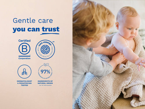 Mustela USA | Toddler applying lotion to a baby wrapped in a beige blanket. - Mustela USA - 5