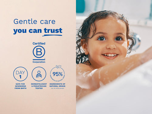 Smiling child taking a bath with wet hair and bubbles, with blue text and icons on the left side of the image. - Mustela USA - 5