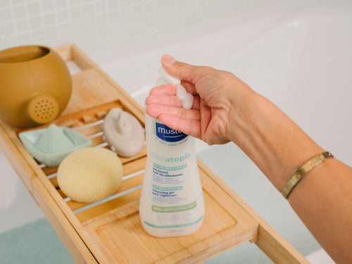 Person using Stelatopia Cleansing Gel Pump in a bathroom - Mustela USA - 3