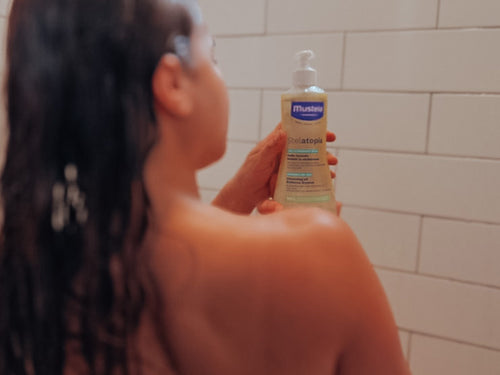 Mustela USA | Person using Stelatopia Cleansing Oil in the shower - Mustela USA - 3