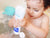 Image of baby squeezing Multi-Sensory Bubble Bath product into the bath