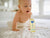 Baby crawling on floor looking at baby oil