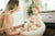 Image of mom and child sitting together holding dry skin products 