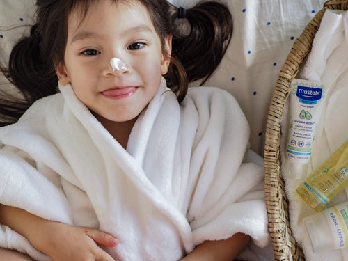 Mustela USA | Hydra Bebe Face Cream in a basket with playful child - Mustela USA - 3
